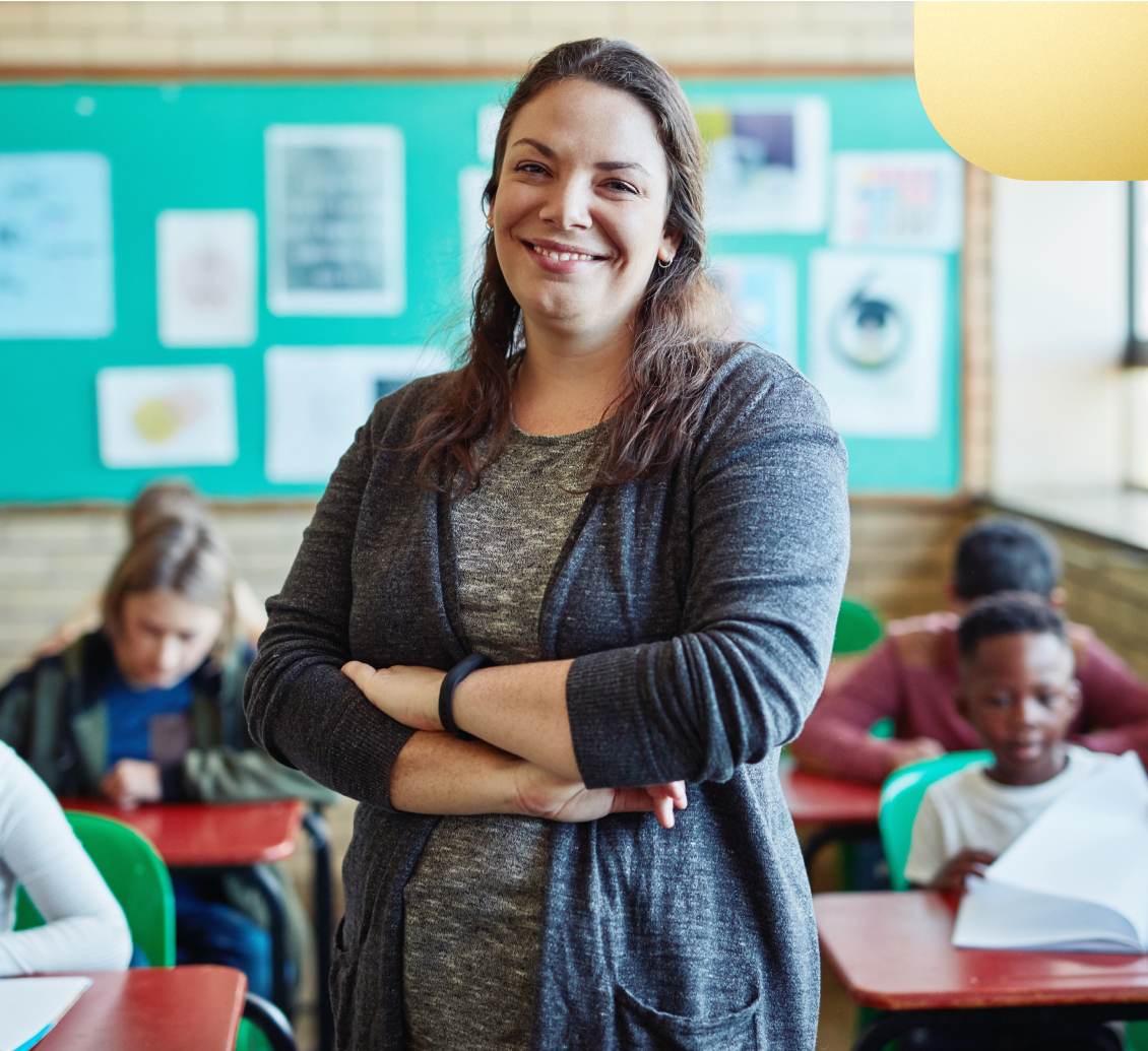 Image of a smiling teacher assisting her students.