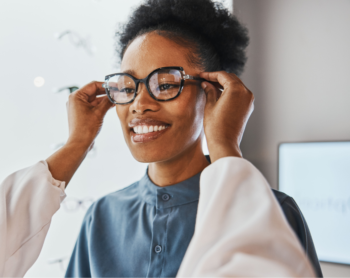 A young female teacher being fitted with a new pair of glasses by her optomologist.